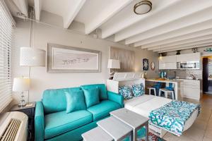 sala de estar con sofá azul y cocina en Fontainebleau Terrace 223, en Panama City Beach