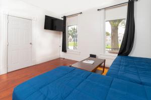 een slaapkamer met een blauw bed en een tafel bij Port Huron Temp Stays - Apartment 2 in Port Huron