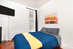 a bedroom with a blue bed and a window at Port Huron Temp Stays - Apartment 2 in Port Huron
