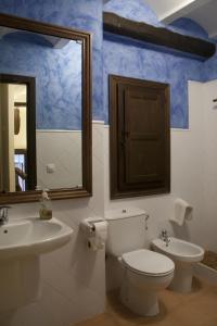 a bathroom with a toilet and a sink and a mirror at Casa el Tilo in Rubiales