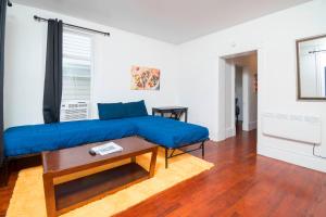 een woonkamer met een blauwe bank en een tafel bij Port Huron Temp Stays - Apartment 2 in Port Huron