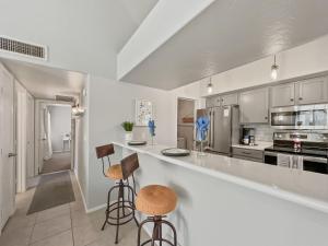 a kitchen with a counter and two bar stools at Lemon Tree #72 Chandler condo in Chandler