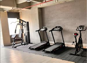 a gym with three treadmills and a brick wall at Class 48, Sabaneta in Sabaneta