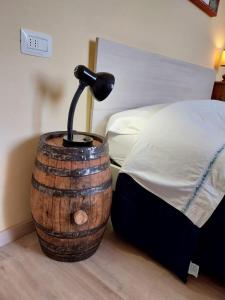 una lampada posta sopra un barile di legno accanto a un letto di Ciclamino fori Porta Pispini 2 a Siena