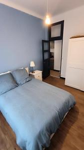 Un dormitorio con una cama grande con una manta azul. en cocooning centre Dinan, en Dinan