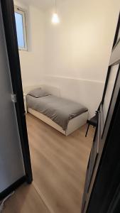 cocooning centre Dinan في دينان: غرفة نوم صغيرة بها سرير ونافذة