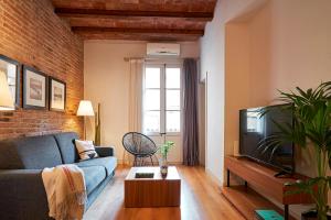een woonkamer met een blauwe bank en een tv bij Catalan Comfort near Sagrada Familia by MyRentalHost in Barcelona