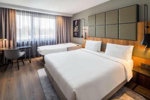 a hotel room with a large bed and a desk at Radisson Blu Hotel, Hamburg Airport in Hamburg