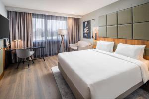 a hotel room with a large bed and a desk at Radisson Blu Hotel, Hamburg Airport in Hamburg