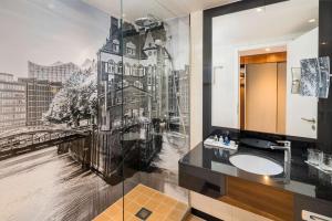 a bathroom with a wall mural of a building at Radisson Blu Hotel, Hamburg Airport in Hamburg