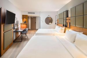 a hotel room with two beds and a desk at Radisson Blu Hotel, Hamburg Airport in Hamburg