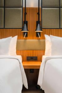 two beds in a hotel room with two lights at Radisson Blu Hotel, Hamburg Airport in Hamburg