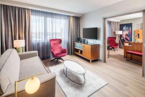 a living room with a couch and a tv at Radisson Blu Hotel, Hamburg Airport in Hamburg