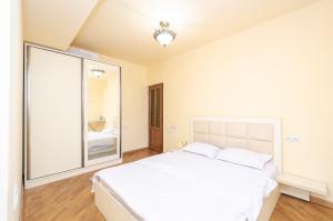 a bedroom with a large white bed and a large mirror at Amiryan15/7 Excellent apartment in the center in Yerevan