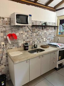 una cucina con lavello e microonde di Chalezim VIP 3 - Chalé Privativo com Hidro - Serra Cipó a Santana do Riacho Altre 8 foto