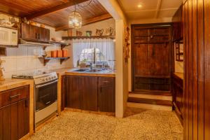 a kitchen with wooden cabinets and a stove top oven at Casa en el centro de la colonia Tovar in El Tigre +17 photos