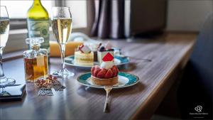 a table with two plates of desserts and glasses of champagne at Daiwa Roynet Hotel Hachinohe in Hachinohe