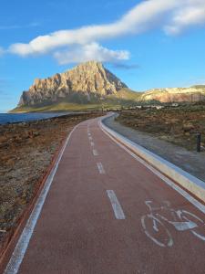 an empty road with a mountain in the background at B & B Baglio Mangiapane in Custonaci