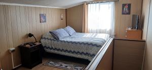 Un dormitorio pequeño con una cama y una ventana. en Cabañas Los Geranios, en Osorno