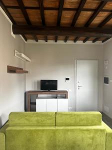 un soggiorno con divano verde e TV di Casa Martina a Capannori