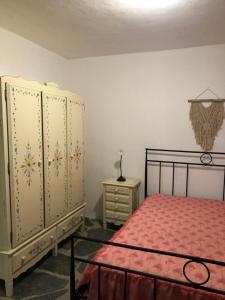 a bedroom with a bed and a dresser and cabinets at Quintinha dos Pombinhos in Montoito