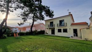a backyard of a house with a yard at Maria Vagueira BeachHouse in Vagos