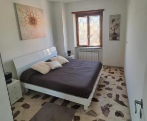 1 dormitorio con 1 cama con 2 almohadas en Roma amoR Vitinia en Vitinia