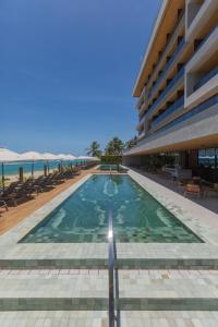 a swimming pool in the middle of a building at Ritz Barra de São Miguel in Barra de São Miguel