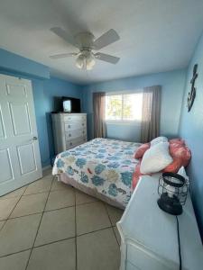 een slaapkamer met een bed en een plafondventilator bij Beachfront condo in paradise in Bradenton Beach