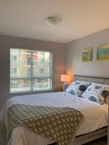 Un dormitorio con una cama grande y una ventana en Waterscapes Osprey 2 Kelowna, en Kelowna