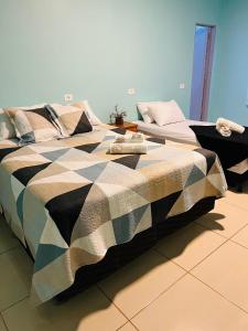 a bed with a black and white comforter in a room at Pousada Love Piri in Pirenópolis