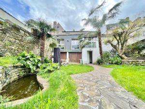 a house with palm trees and a stone walkway at LA VILLA AU DUC - Standing - Jardin Clos - Plein Centre Ville ! in Quimper