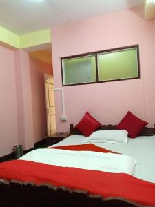 - une chambre avec un grand lit et des oreillers rouges dans l'établissement Capital O Sillery Gaon, à Pedong