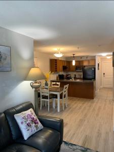 a living room and kitchen with a couch and a table at Waterscapes Osprey 2 Kelowna in Kelowna