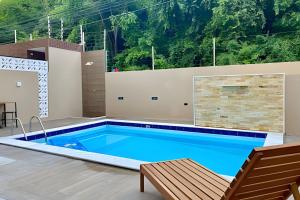 a swimming pool in a house with a table and a chair at Apto 3 quartos com piscina e pertinho da praia. in João Pessoa