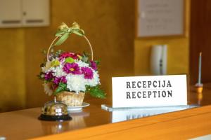ein Blumenkorb auf einem Tisch mit einem Schild in der Unterkunft Apartments Ivona in Budva