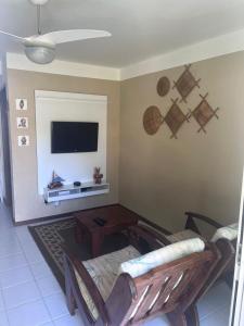 CamassariにあるVilage 3/4 aconchegante em Guarajubaのソファと薄型テレビのあるリビングルーム