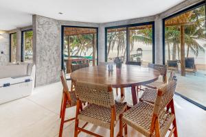 a dining room with a wooden table and chairs at Villa Tankah 7 Cielo in Tulum