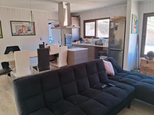 sala de estar con sofá azul y cocina en Casa curacaví 8 personas, en Curacaví