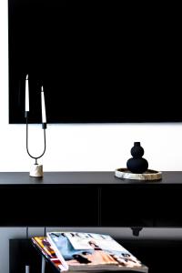 a table with a tv and a lamp and a magazine at Elysian Haven in Athens
