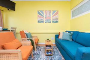 ein Wohnzimmer mit einem blauen Sofa und Stühlen in der Unterkunft Sunny Daze Beach Condo in Myrtle Beach