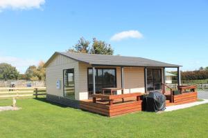 a tiny house with a porch and a deck at Benn Rd Cottage in Cambridge