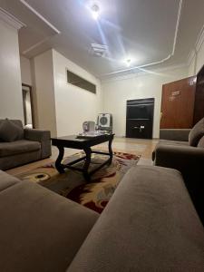 een woonkamer met een bank en een tafel bij اجنحه ايلاف الفندقية in Abha
