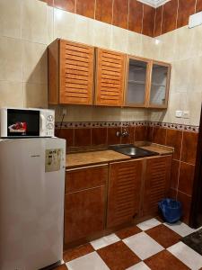 een keuken met een wastafel en een koelkast bij اجنحه ايلاف الفندقية in Abha