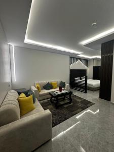 ein Wohnzimmer mit einem Sofa und einem Tisch in der Unterkunft اجنحه ايلاف الفندقية in Abha