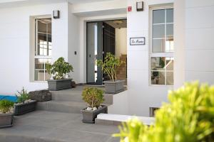 a white building with potted plants on the stairs at La Marina in Puerto del Carmen