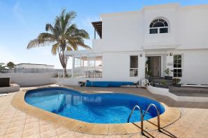 a villa with a swimming pool in front of a house at La Marina in Puerto del Carmen +3 photos