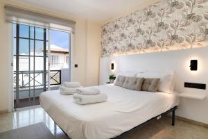 a bedroom with a large white bed with towels on it at La Marina in Puerto del Carmen