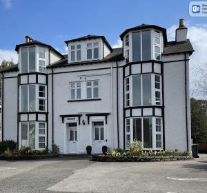 a large white house with black and white windows at Mere View Loft, Bowness-on-Windermere in Bowness-on-Windermere