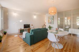 uma sala de estar com um sofá verde e uma mesa em NEW - Bright Studio in Santa Catarina no Porto